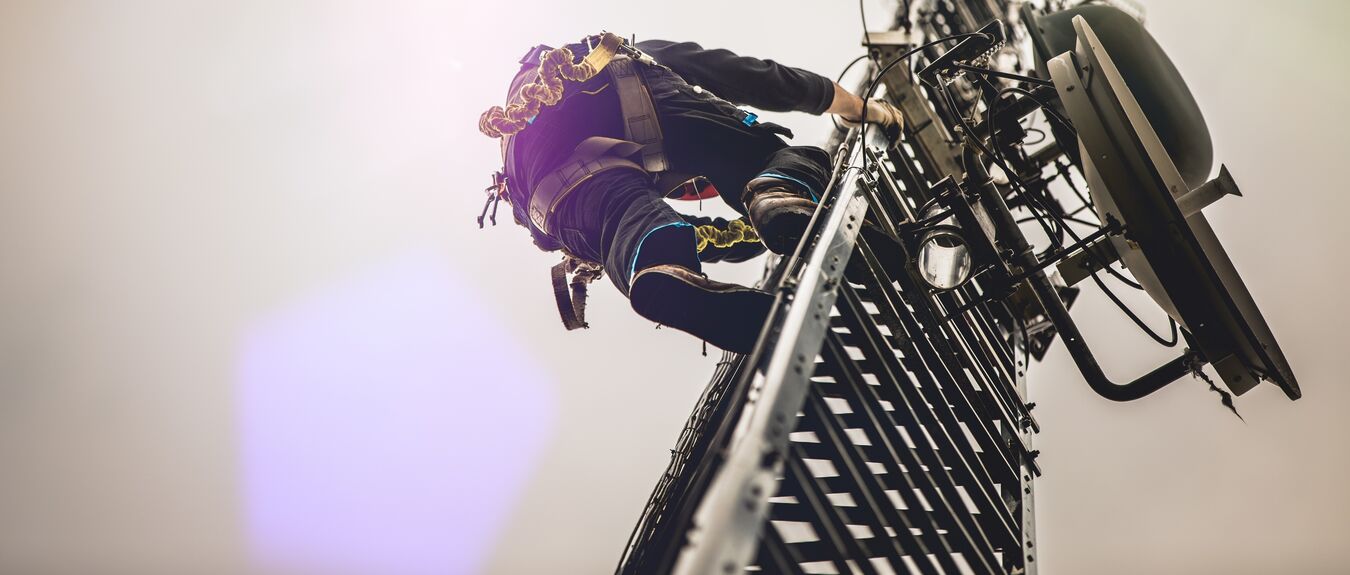 telecom worker climbing antenna tower